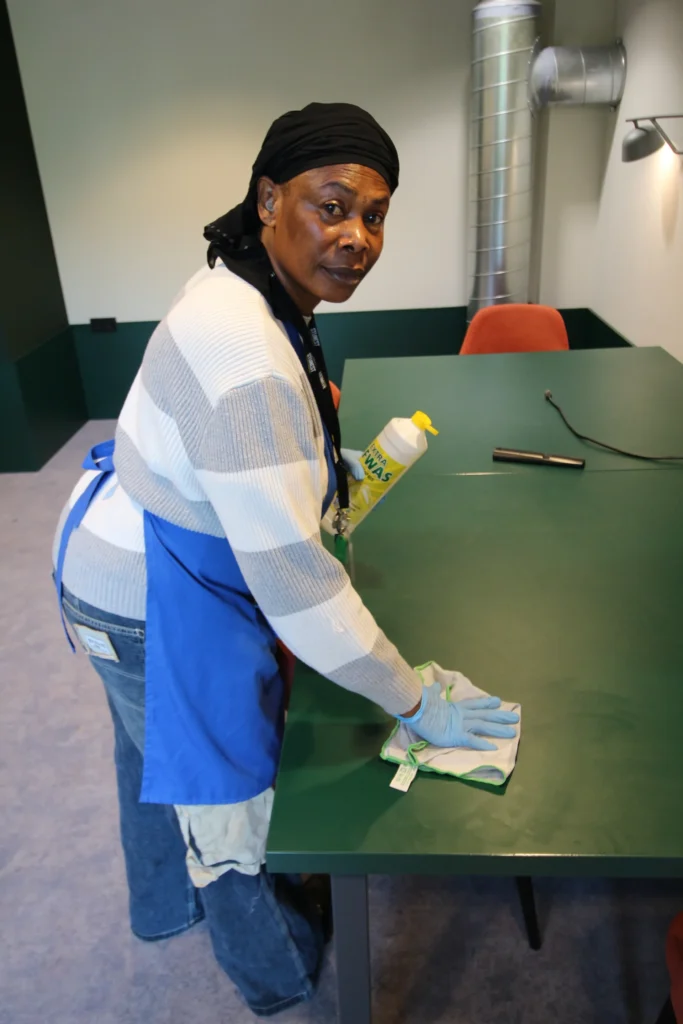 Medewerker van NCS Schoonmaak neemt een vergadertafel af in een bedrijfspand in Maastricht